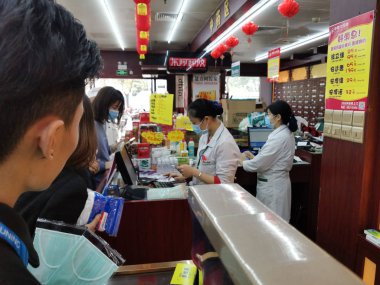 Zhongshan Çin-24 Ocak 2020: İnsanlar bir uyuşturucu dükkanından maske satın alıyor. Herkes kendini 2019-ncov 'a karşı koruyor..