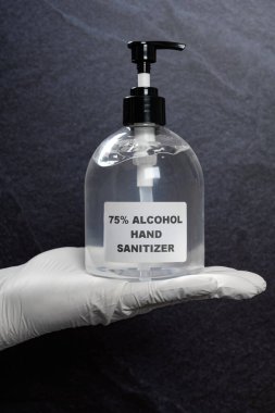 % 75 'lik alkol şişesini tutan el dezenfektanı.