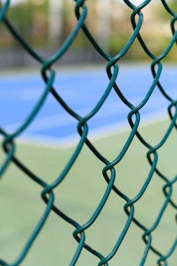 Tenis kortu tel örgülerin arkasında dikey kompozisyon