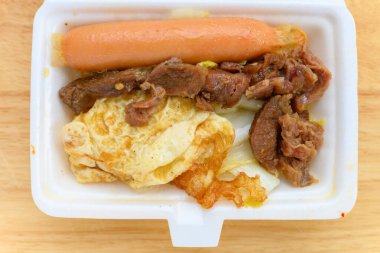 Buharda pişirilmiş tavuk budu, sosis ve lahana.