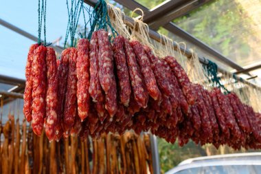 Raflarda asılı duran kurutulmuş sosisler ve ördekler