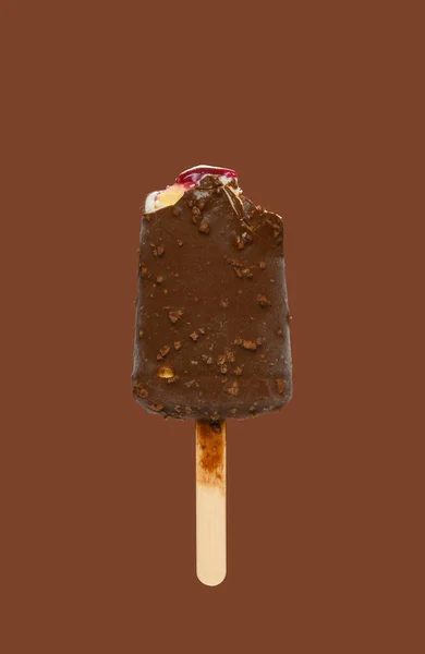 chocolate outer popsicle with blueberry sauce inside with some bites on brown background