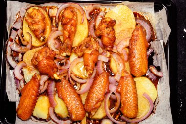 Üst manzara taze fırınlanmış tavuk kanadı soğan ve patates.