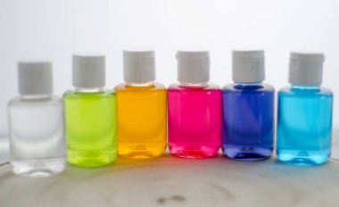 Beyaz arkaplanda parlak renkli bir sıvı var..