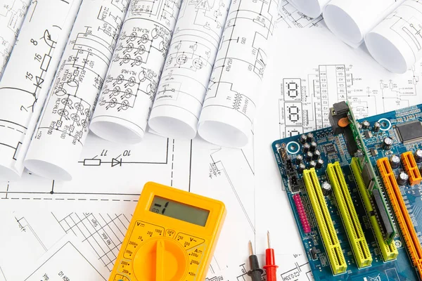 electrical engineering drawings, computer motherboard and digital multimeter