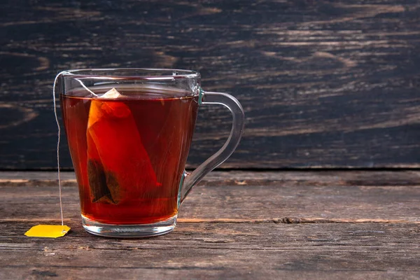 玻璃杯红茶 茶袋放在木制桌子上 — 图库照片