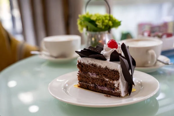 Delicious three layer chocolate cake with shavings and a cherry