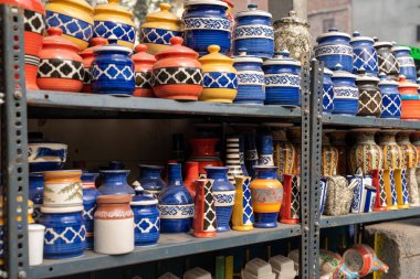 Sıralar ve raflar çeşitli renkli seramik kavanozlar ve vazolar için 