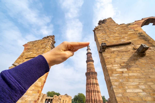 Tourist takes a forced perspective photo of her hand touching th — Stock Photo, Image