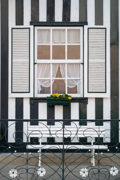 Utsmyckat fönster med fönsterluckor och bänk i svart och vitt band — Stockfoto