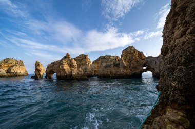 Algarve Portekiz 'deki Ponta da Piedade' de turkuaz suyla Algarve kıyılarının doğal kayalık oluşumları ve kemerleri.
