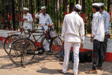Mumbai, India - February 29, 2020: Dabbawala bicycle couriers get ready to deliver lunch boxes around Mumbai to workers around the city