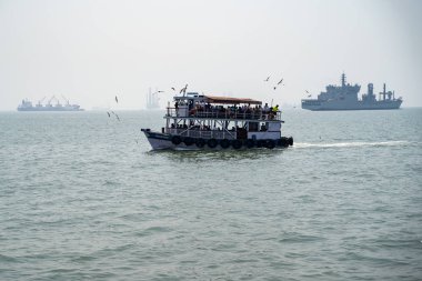 Mumbai, India - March 1, 2020: Seagulls and pigeons surround a ferry headed to Elephanta Island Caves, wanting passengers to feed them food
