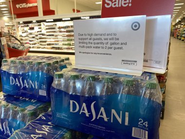 Eau Claire, Wisconsin - March 30, 2020: Sign on top of a stack of Dasani bottled water reminds customers that quantities are limited to 2 cases per customer clipart