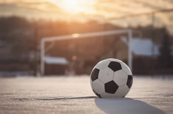 Fotboll i solnedgången på vintern — Stockfoto
