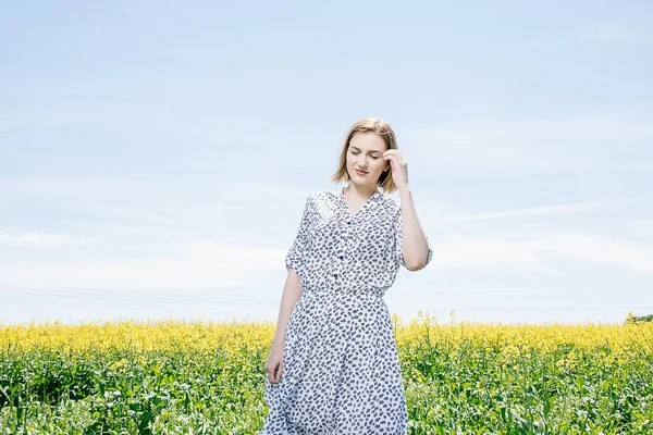 Sarı tecavüz, bir field yakınındaki bir alan Road elbiseli kız genç bir kadın bir ahşap kutu üzerinde oturur..