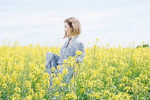 Sarı tecavüz, bir field yakınındaki bir alan Road elbiseli kız genç bir kadın bir ahşap kutu üzerinde oturur..