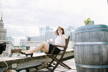 Kız Kültür Sarayı'nın Varşova, bir iş kadını bakan bir kitap okur. Bayan masada oturur, kahve içer ve işten rahatlatır. Ara çalışma. Güzel gün.