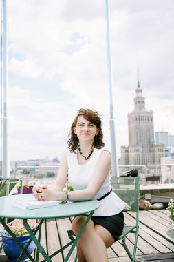 Kız Kültür Sarayı'nın Varşova, bir iş kadını bakan bir kitap okur. Bayan masada oturur, kahve içer ve işten rahatlatır. Ara çalışma. Güzel gün.