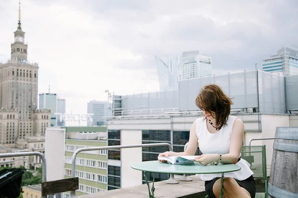 Kız Kültür Sarayı'nın Varşova, bir iş kadını bakan bir kitap okur. Bayan masada oturur, kahve içer ve işten rahatlatır. Ara çalışma. Güzel gün.