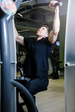 Bir adam bir blok simülatörü bir spor salonunda devreye girer.