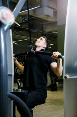 Bir adam bir blok simülatörü bir spor salonunda devreye girer.