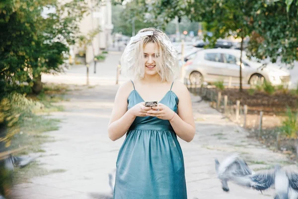 Girl with a haircut. Young woman with pigeons. An early walk of the city\'s streets. Sunrise in the city.