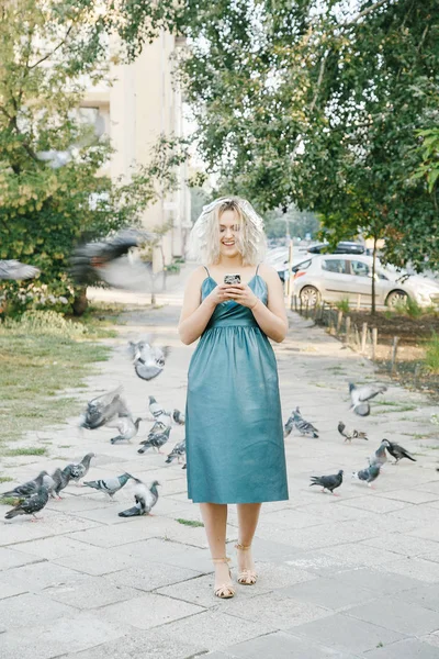Girl with a haircut. Young woman with pigeons. An early walk of the city\'s streets. Sunrise in the city.