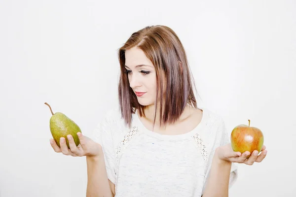 女の子は リンゴと梨を保持します 若い女性には 果実が保持しています リンゴと梨の間の選択 — ストック写真
