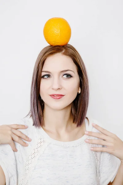 オレンジ色を保持している女性 柑橘類と若い女性 女の子の頭の上のオレンジ — ストック写真