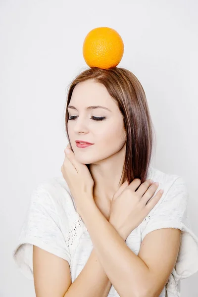 オレンジ色を保持している女性 柑橘類と若い女性 女の子の頭の上のオレンジ — ストック写真