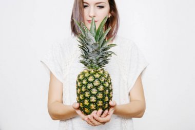 Kız ananas tutar. Ananas olan kadın. meyve ve sebze ellerinde. ananas kafasına.