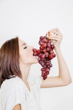 Kız kara üzüm onun elinde tutar. Üzüm bir küme olan bir genç kadın. Genç bir kadın ellerinizde asma.