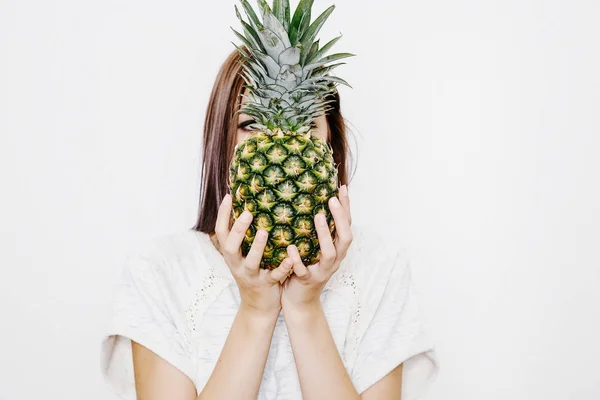 女の子は パイナップルを保持しています パイナップルと若い女性 果物や野菜を手に 頭の上のパイナップル — ストック写真