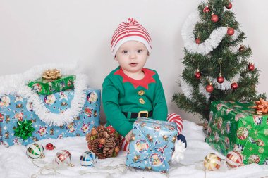 Noel Elf kostümü çocuk. Bir Noel ağacı yakınındaki bir bebek.