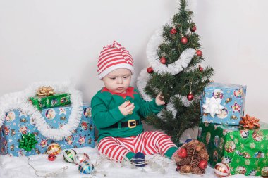Noel Elf kostümü çocuk. Bir Noel ağacı yakınındaki bir bebek.