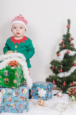 Noel Elf kostümü çocuk. Bir Noel ağacı yakınındaki bir bebek.