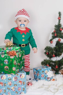 Noel Elf kostümü çocuk. Bir Noel ağacı yakınındaki bir bebek.