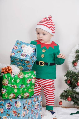 Noel Elf kostümü çocuk. Bir Noel ağacı yakınındaki bir bebek.