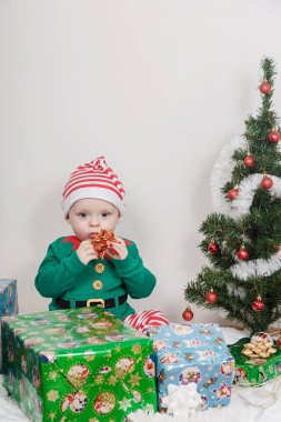 Noel Elf kostümü çocuk. Bir Noel ağacı yakınındaki bir bebek.