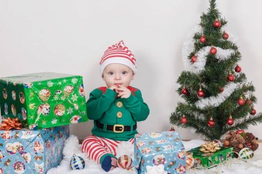 Noel Elf kostümü çocuk. Bir Noel ağacı yakınındaki bir bebek.
