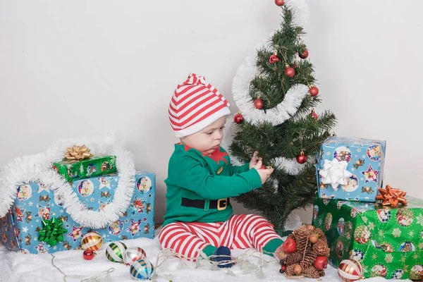 Noel Elf kostümü çocuk. Bir Noel ağacı yakınındaki bir bebek.