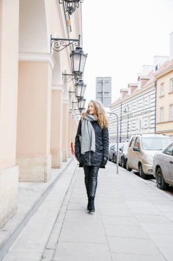 Eski şehri dolaş. Genç bir kadın seyahat ediyor. Varşova 'daki Pazar Meydanı. Kıvırcık kız şehrin sokaklarında yürüyor.