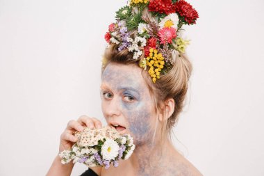 Onun kafası ve elleri üzerinde çiçekler olan bir genç kadın. Çiçekli bahar görüntü. Kız ve çiçek açan saç kesimi ve brokar yüzünde.