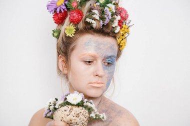 Onun kafası ve elleri üzerinde çiçekler olan bir genç kadın. Çiçekli bahar görüntü. Kız ve çiçek açan saç kesimi ve brokar yüzünde.