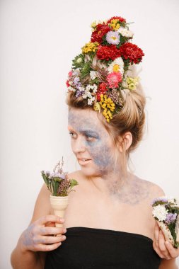 Onun kafası ve elleri üzerinde çiçekler olan bir genç kadın. Çiçekli bahar görüntü. Kız ve çiçek açan saç kesimi ve brokar yüzünde.