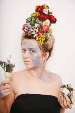 Onun kafası ve elleri üzerinde çiçekler olan bir genç kadın. Çiçekli bahar görüntü. Kız ve çiçek açan saç kesimi ve brokar yüzünde.