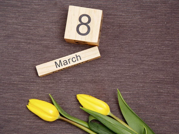 De inscriptie op 8 maart met bloemen op een grijze achtergrond — Stockfoto