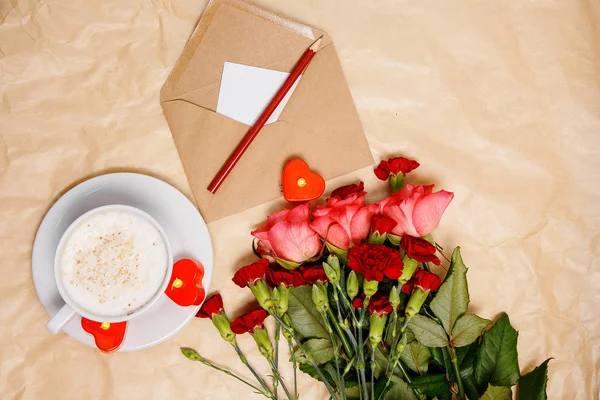 A cup of coffee, flowers and a envelope