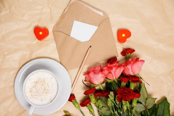 A cup of coffee, flowers and a envelope